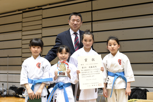 大会実行委員長の遠藤隆夫先生と小学3・4年女子団体組手で準優勝した遠藤道場の皆さん